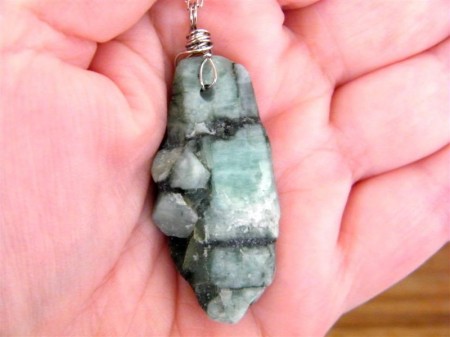 Raw Emerald Necklace Back on Hand